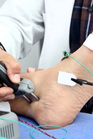 doctor performs electromyography on patient's feet