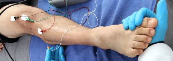 doctor performs electromyography on patient's feet